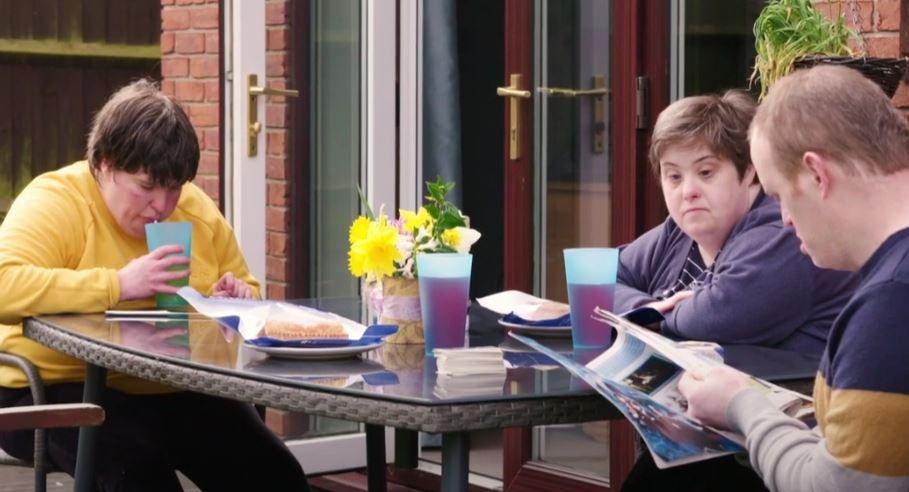 Photo of Chelsea Sarah and David enjoying a snack in the garden where they live together